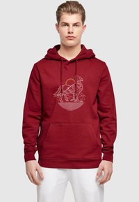 Burgundy hoodie i mjukt material med en framficka och en grafisk bild av en fågel mot en sol och berg, med ribbade ärmslut.