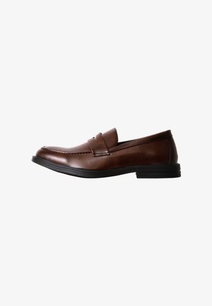 Mocassin en cuir marron à enfiler avec semelle noire, bout arrondi et une sangle sur le dessus, présenté de profil sur fond blanc.
