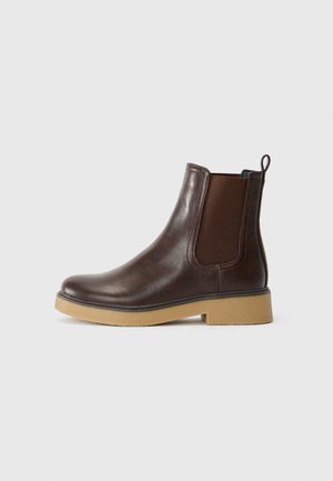 Brun Chelsea-støvle i læder med elastisk sidepanel, trækstrop ved hælen og lys tan gummisål.