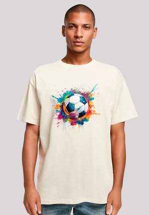 Cream cotton t-shirt featuring a colorful, splatter-painted soccer ball graphic at the center. Relaxed fit, short sleeves.