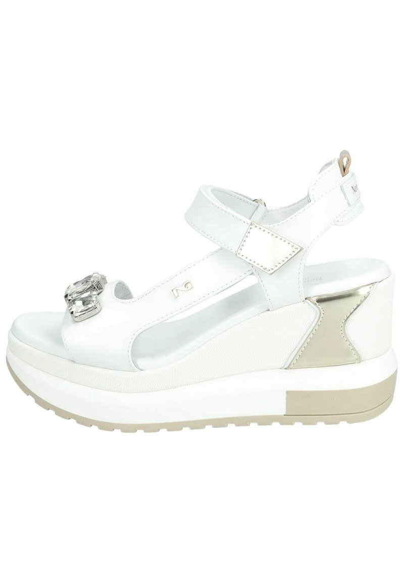 Sandali wedge bianchi con dettaglio della fibbia lucida, cinturini in pelle e accenti testurizzati. Presentano una suola piattaforma con una base marrone chiaro.
