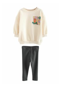 Krämfärgad sweatshirt med puffärmar, färggrafisk tryck och text på bröstet, kombinerad med svarta ribbade leggings. Mjuk tyg.