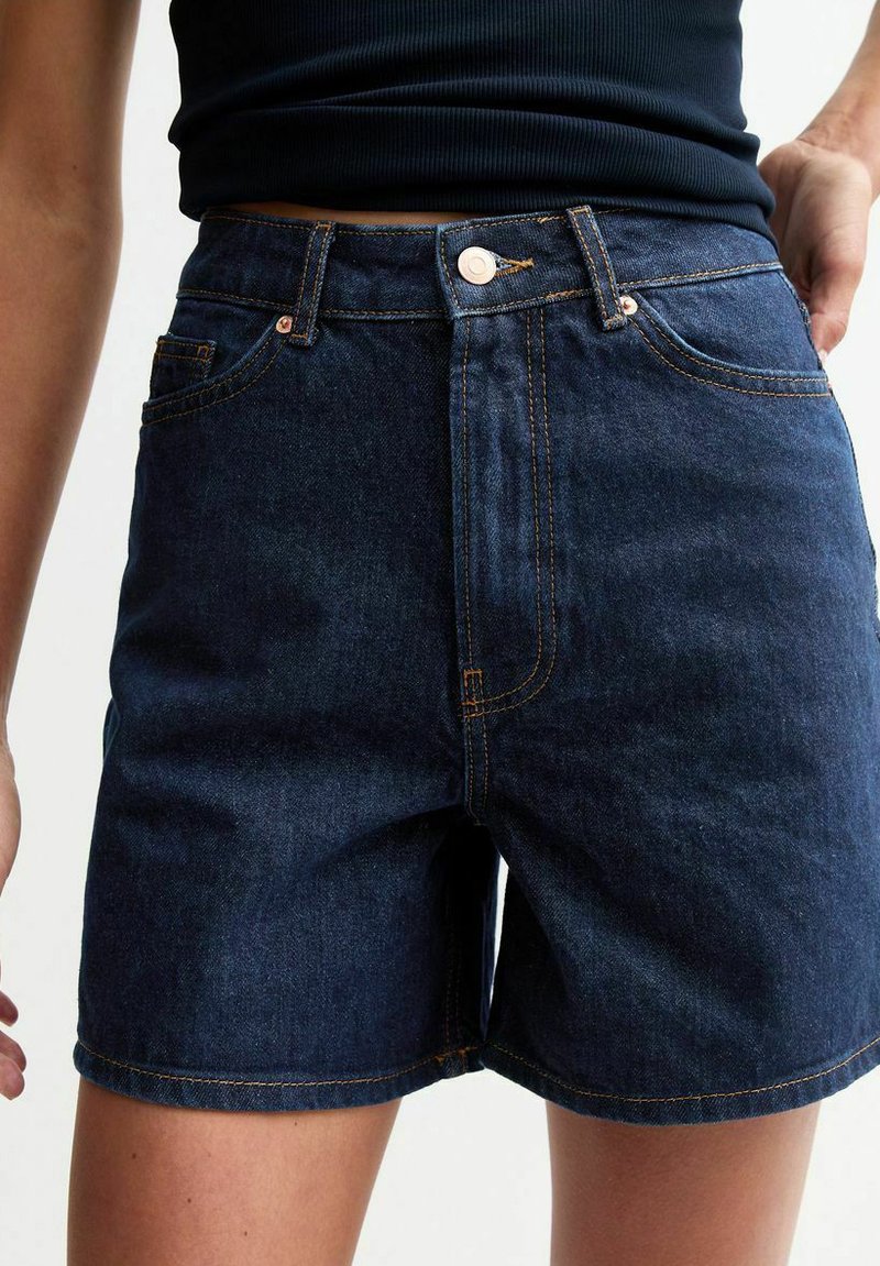 Mörkblå denimshorts med hög midja, med orange sömmar, framfickor och metallknäppning.