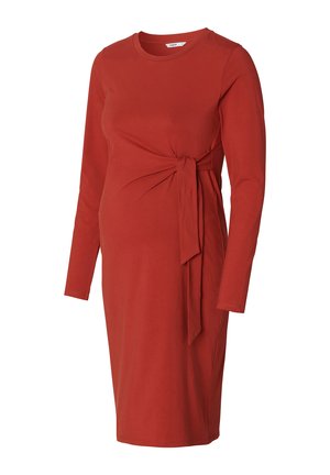 Robe de maternité rouge à manches longues en tissu doux, avec une silhouette ajustée, présentant un accent de lien sur le côté et un col rond.