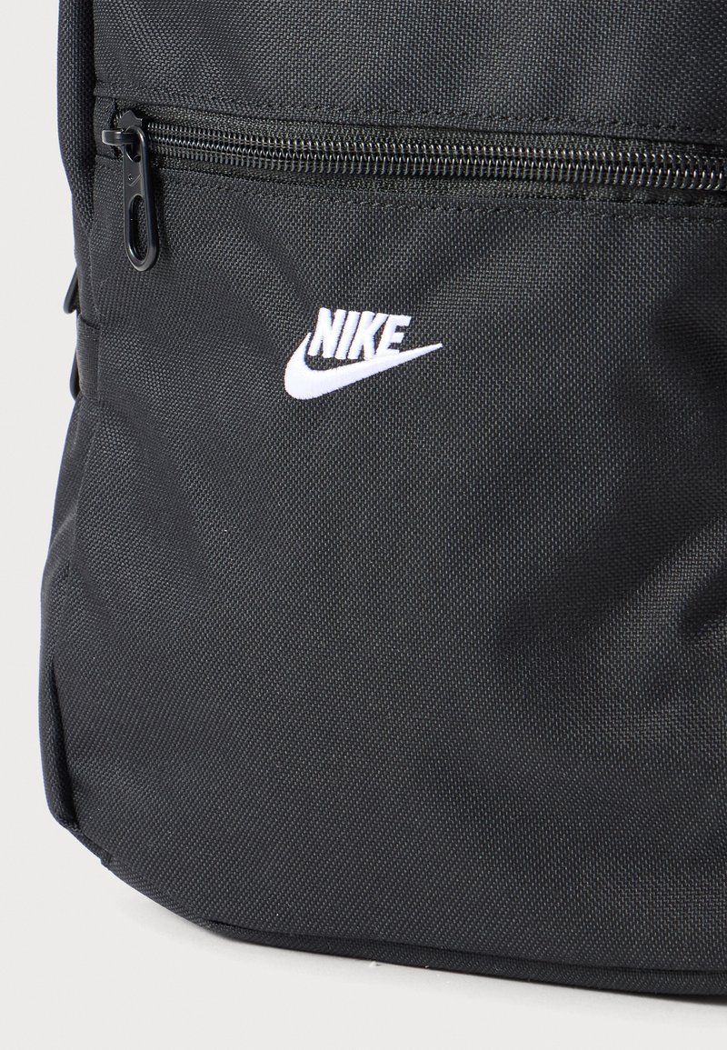 Zaino Nike nero strutturato con tasca frontale con zip nera e logo Nike bianco con swoosh al centro della tasca.