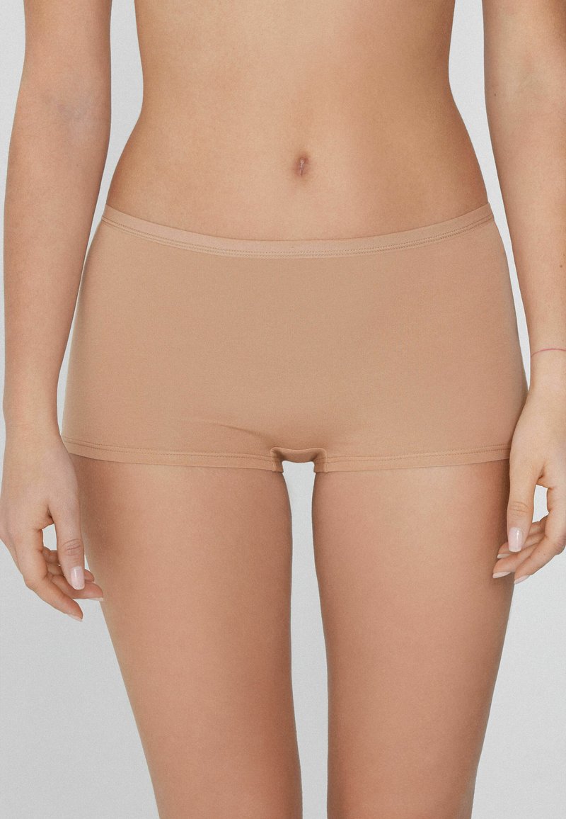 Beige bavlněné hipster šortky s hladkým povrchem, elastickým páskem a délkou do poloviny stehna. Bez viditelných švů. Vhodné pro každodenní nošení.