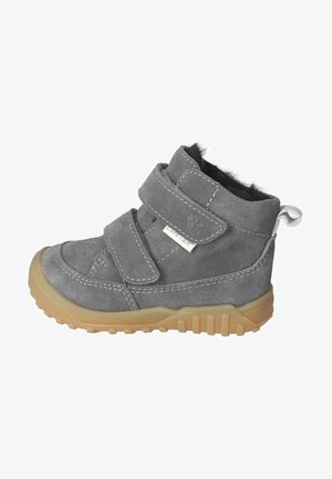 Graue Wildleder-Stiefelette mit zwei Klettverschlüssen, weicher Innenausstattung, robuster, tannfarbener Gummisohle und dekorativen Nähten entlang der Kanten.
