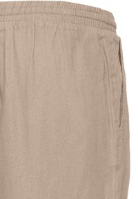 Pantalon beige en lin avec une ceinture élastique et une poche latérale visible sur fond blanc.