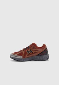 Scarpa da corsa con tomaia in rete rossa con dettagli neri e argentati, colletto imbottito e suola grigia testurizzata con maggiore aderenza.