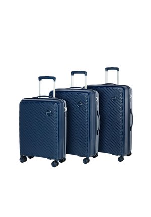 Three navy blue hard-shell suitcases with diagonal ridges, extendable handles, and smooth spinner wheels, varying in size and height.