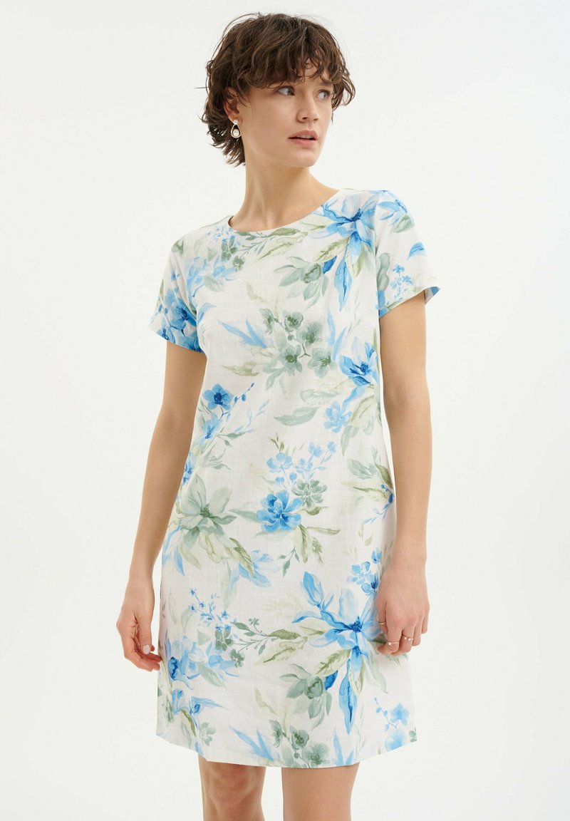 Kwiatowa sukienka z krótkimi rękawami, wykonana z lekkiej tkaniny. Wzór przedstawia niebieskie kwiaty i zielone liście na jasnym tle. Prosty design.