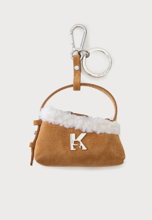 Pochette à clés en daim marron avec bordure en polaire blanche, emblème argenté "K", poignée courte, porte-clés argenté et mousqueton sur fond blanc.