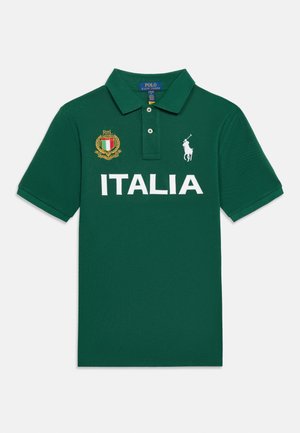Πράσινο κοντομάνικο πόλο με το κείμενο "ITALIA", το οικόσημο της Ιταλίας στο αριστερό στήθος και λευκό λογότυπο παίκτη πόλο στο δεξί στήθος.