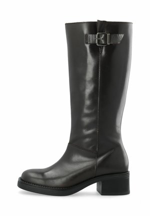 Botte en cuir noire mi-mollet avec un petit talon bloc et une sangle décorative à boucle près du dessus, vue de côté sur fond blanc.