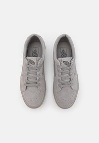 Graue Wildleder-Sneaker mit runder Zehenform, Schnürung an der Vorderseite, perforierten Details und einer Gummisohle. Die Innensohle zeigt das Vans-Logo.