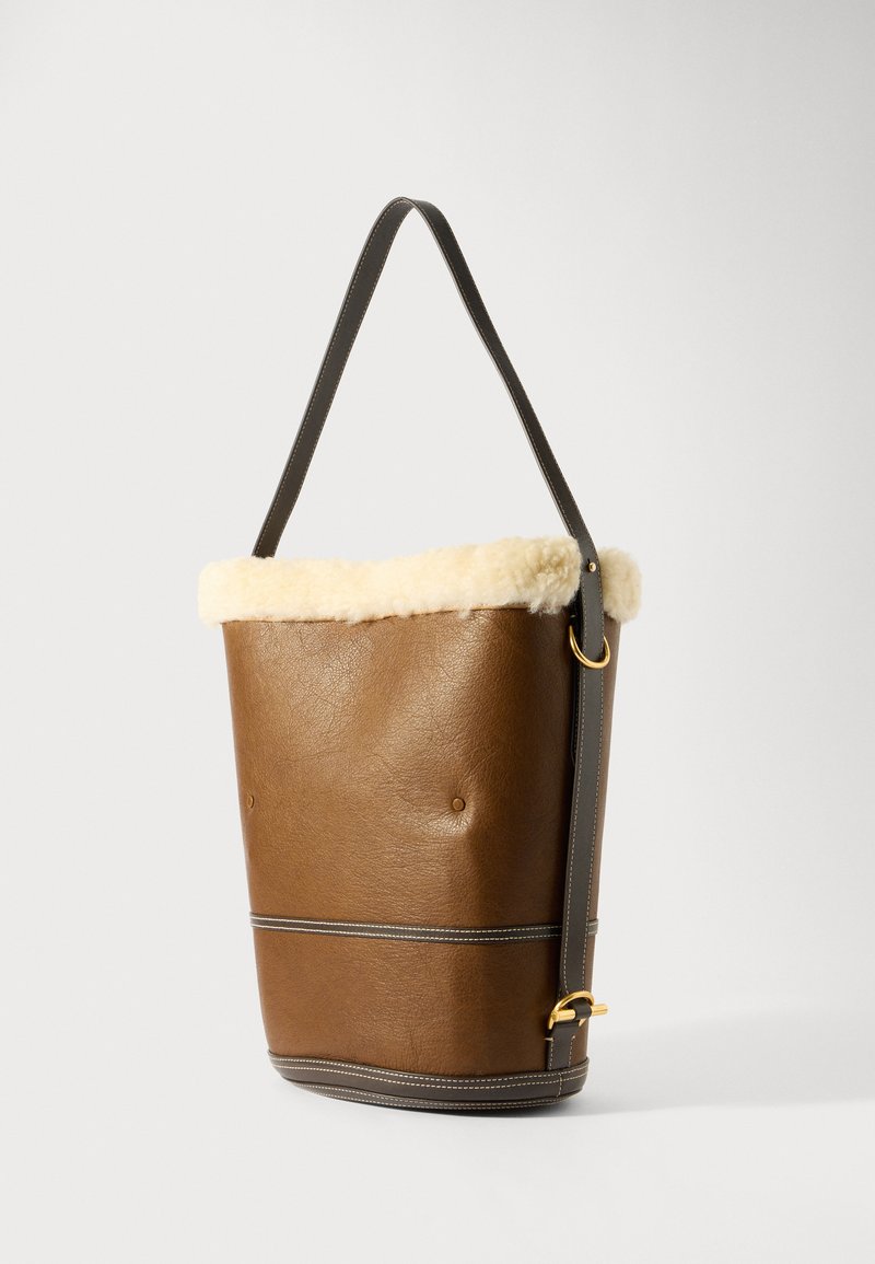 Borsa a secchiello in pelle marrone con parte superiore in shearling crema, tracolla in pelle grigia, dettagli in anelli dorati e una texture liscia; presenta dettagli di cucitura.