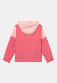 Vaaleanpunainen kevyt takki hupulla. Ominaisuuksiinsa kuuluu vaaleanpunaiset kontrastiväriset hihat. Valmistettu sileästä, kiiltävästä kankaasta, ja siinä on elastiset hihansuut sekä helma.