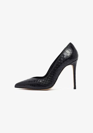 Escarpin noir à talon aiguille avec un bout pointu et un motif en relief de serpent. Talon stiletto mesurant environ 10 cm. Doublure intérieure lisse.