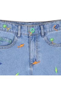 Μπλε τζιν σορτς με ζωηρά κεντήματα που απεικονίζουν καρχαρίες, φοίνικες και σανίδες σερφ, με πράσινο κουμπί και λεπτομερές ράψιμο.