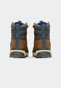 Bottes en cuir marron et en tissu gris avec des cols rembourrés, des tirettes bleues et des semelles en caoutchouc noir, arborant un logo à l'arrière.