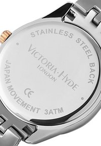 Fondo de reloj de acero inoxidable plateado con texto grabado; incluye el nombre de la marca "Victoria Hyde", resistencia al agua indicada como 3ATM y movimiento de Japón.