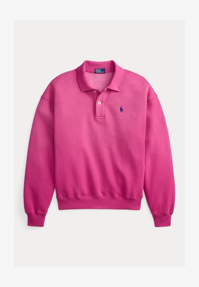 Roza polo majica z dolgimi rokavi z rebrastimi manšetami, z dvema gumboma na ovratniku in majhnim modrim izvezenim logotipom na prsih. Mehka mešanica bombaža.