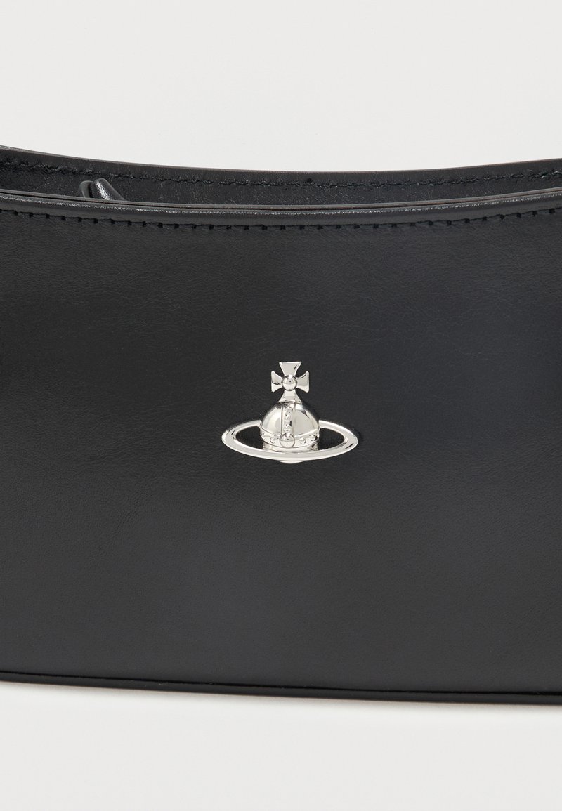 Sac à main en cuir noir avec surpiqûres visibles et petit emblème argenté en forme d'orbe et de croix au centre avant.