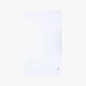 Serviette de bain en coton blanc avec une texture éponge bouclée. Elle présente un design uni avec une bande horizontale et un petit logo dans un coin.
