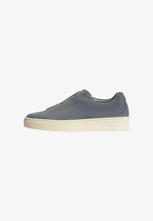 Sneaker grigio in suede senza lacci, con una superficie liscia, punta tonda e suola in gomma bianca. Senza lacci, presenta dettagli cuciti lungo i lati.