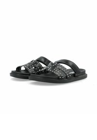 Sandales noires en cuir avec des accents cloutés, dotées de larges lanières et d'une semelle plate, conçues pour le confort et la facilité d'enfilage.