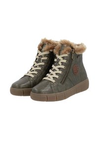 Baskets montantes en cuir vert avec un col en fausse fourrure beige, lacets beiges, fermeture éclair sur le côté et semelle en caoutchouc texturée.