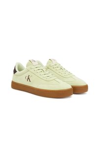 Sneakers in suede verde chiaro con suola in gomma marrone, caratterizzate da un logo sul lato e una linguetta a contrasto. Design con lacci, texture liscia.