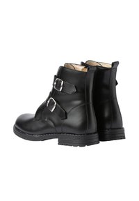 Botas de cuero negro hasta el tobillo con dobles correas de hebilla plateadas y tiradores en el talón, mostradas desde un ángulo posterior a tres cuartos.