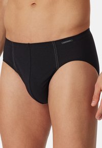 Zwarte katoenen slipjes met een aansluitend ontwerp, subtiele stikdetails en een klein logo-label op de tailleband.