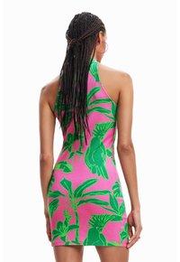 Abito aderente senza maniche con una texture a coste; sfondo rosa vivace con grandi motivi di foglie tropicali verdi e pappagalli.