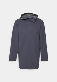 Veste imperméable bleu marine avec capuche, manches longues, fermeture éclair frontale, deux poches latérales et poignets texturés. Matière extérieure lisse, doublure grise.