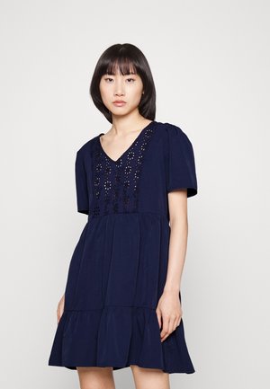 Navy blue short-sleeved dress with a V-neckline, floral embroidery detail on the bodice, and a tiered ruffled hem. Soft, lightweight fabric.