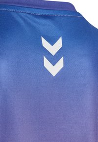 Blå sporttröja med en gradientstruktur. Har en rund krage och tre vita chevronränder på baksidan. Slät, syntetisk tyg.