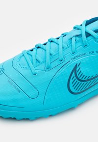 Zapatilla deportiva azul claro con un upper texturizado, que presenta acentos en azul oscuro y detalles impresos. Cuerdas y un diseño aerodinámico para mayor velocidad.