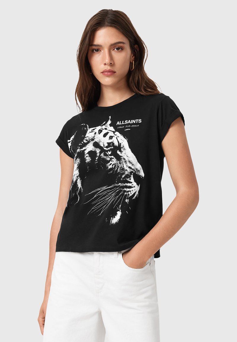 Camiseta de algodón negra con un gráfico de tigre blanco y el logo de la marca. Cuello redondo, mangas cortas, corte relajado y textura suave.
