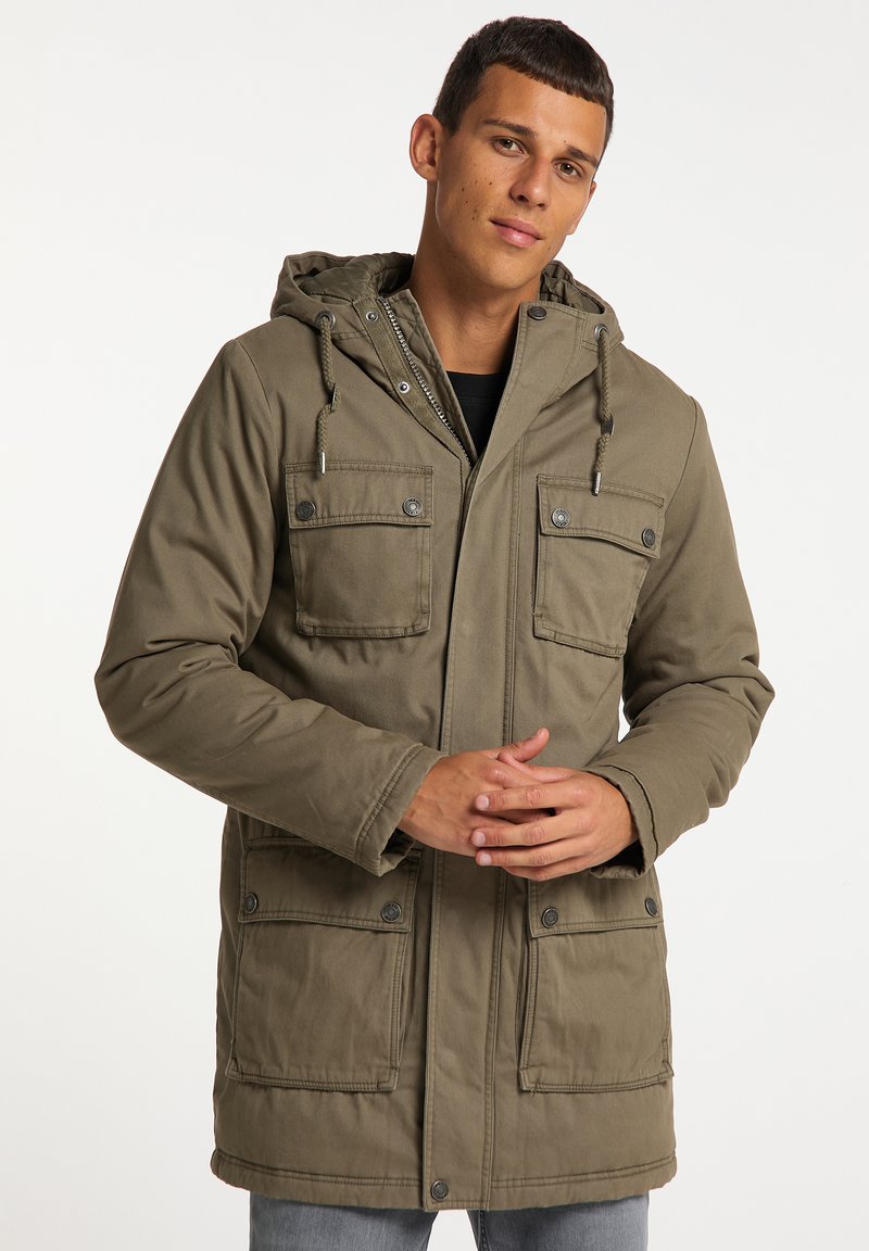 Giacca parka verde oliva con cappuccio, dotata di quattro tasche frontali, bottoni a pressione e un tessuto texturizzato. Design semplice, vestibilità casual.