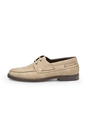 Scarpa da barca in camoscio beige con punta tonda, design con lacci e occhielli metallici. Caratterizzata da una suola testurizzata e da un battistrada in gomma marrone a contrasto.