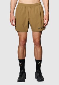 Bruine shorts met een elastische tailleband en zijzakken. Heeft "ATW" in het zwart gedrukt. Draag ze met zwarte sokken en hardloopschoenen.