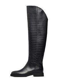 Stivali neri al ginocchio realizzati in pelle testurizzata con un motivo a coccodrillo, con suola piatta e punta rotonda. Finitura liscia lungo il bordo.