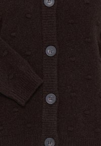 Cardigan en maille marron foncé avec des boutons visibles sur le devant et un bord-côtes au niveau de la manche.
