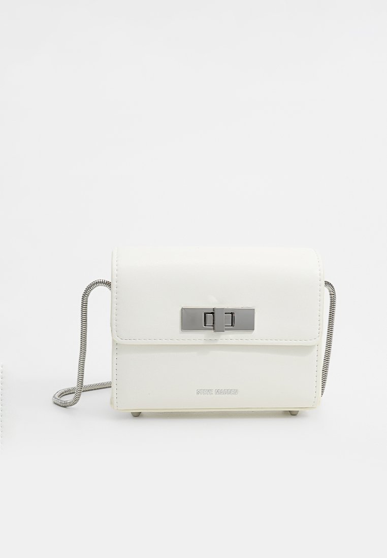 Weiße Kunstleder-Crossbody-Tasche mit Klappenverschluss, silbernen Beschlägen und einer Kettenriemen. Sie verfügt über eine glatte Textur und eine minimale Markenpräsentation.