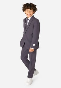 Grau Anzug mit Einreiher-Jacke, mit Revers und passender Hose. Vervollständigt mit einem weißen Hemd und einer Krawatte sowie weißen Sneakers.