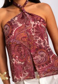 Top à encolure halter avec un motif floral paisley dans des teintes bourgogne, rose et orange, fabriqué dans un tissu léger avec une coupe ample.