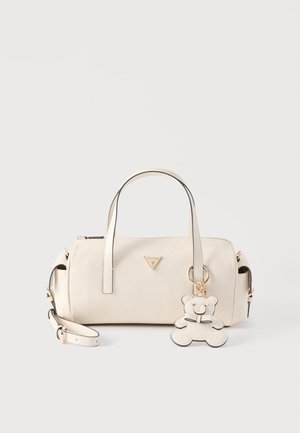 Sac à main en cuir crème avec doubles poignées, bandoulière amovible, ferrures dorées et un porte-clés en forme d'ours en peluche fixé à l'avant.