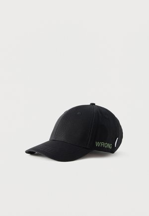 Casquette de baseball noire avec une visière incurvée et un petit texte vert "WRONG" brodé sur le panneau latéral.